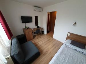 Camera con letto e scrivania con TV di Citylife Rooms a Mosonmagyaróvár