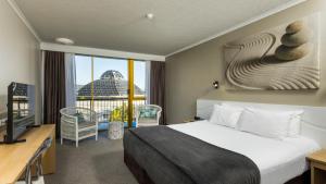 um quarto de hotel com uma cama e uma grande janela em Pacific Hotel Cairns em Cairns