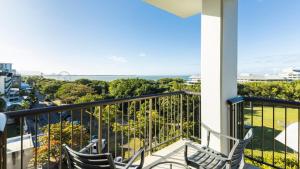 Duas cadeiras sentadas numa varanda com vista para o oceano em Pacific Hotel Cairns em Cairns