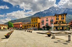 una strada cittadina con edifici e montagne sullo sfondo di Greta House a Colico