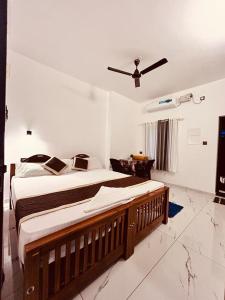 a bedroom with a large bed with a ceiling fan at ENOCEAN HOMESTAY in Cherai Beach