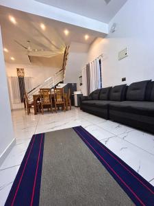 a living room with a black couch and a table at ENOCEAN HOMESTAY in Cherai Beach