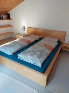 1 dormitorio con 1 cama con marco de madera en Moderne attraktive Dachwohnung für max. 6 Personen in ruhiger Umgebung, en Flims