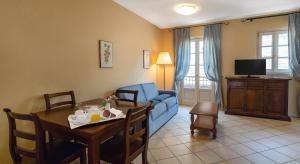 a living room with a blue couch and a table at Residenza dei Fiori in Cannero Riviera