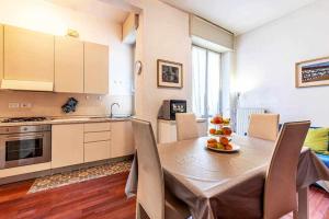 a kitchen with a wooden table with chairs and a dining room at SAN SIRO a 7 minuti Stanza Top con zone Comuni in Milan