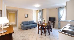 a living room with a table and a blue couch at Residenza dei Fiori in Cannero Riviera