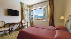 a hotel room with a bed and a window at Residenza dei Fiori in Cannero Riviera