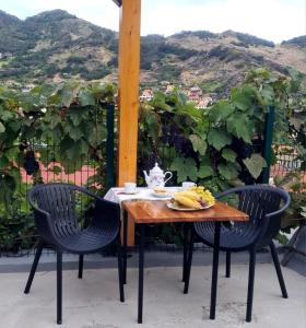 una mesa con dos sillas y un plato de plátanos en ella en Studio em Machico, en Machico