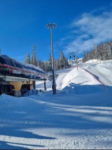 uma pista de esqui coberta de neve com um teleférico em Jahorinska Vila em Jahorina