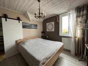 um quarto com uma cama, uma janela e um lustre em Villa les Buissonets em Berck-sur-Mer