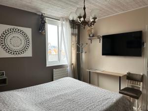 um quarto com uma cama e uma televisão de ecrã plano em Villa les Buissonets em Berck-sur-Mer