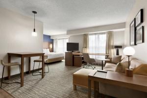 Residence Inn Houston The Woodlands/Market Street في ذا وودلاندس: فندق غرفه بسرير وصاله