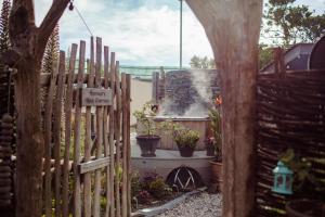 een houten hek in een tuin met potplanten bij Bedruthan Hotel & Spa in Newquay