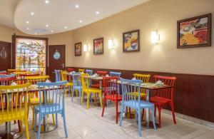 una sala da pranzo con tavoli e sedie colorati di Hotel Terminus Montparnasse a Parigi