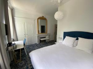 um quarto com uma grande cama branca e um espelho em Logis HOTEL DU PARC em Pont-à-Mousson