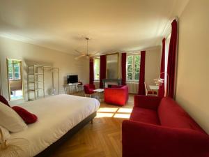 um quarto com uma cama e um sofá vermelho em Logis HOTEL DU PARC em Pont-à-Mousson