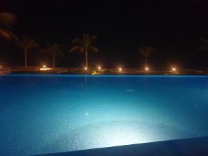 una gran piscina por la noche con palmeras en Sunrise Sifah, en As Sīfah