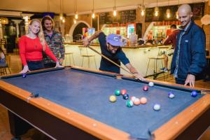 Un groupe de personnes autour d'un billard dans l'établissement Socialtel Antigua - formerly Selina Antigua, à Antigua Guatemala