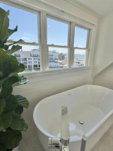 un bagno con lavandino bianco e due finestre di Harborside Inn a Newport