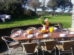 una mesa de madera con un bol de fruta. en Super Spacious Country house pet/party friendly., en Newquay