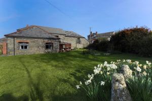 una casa con un jardín con flores delante en Super Spacious Country house pet/party friendly., en Newquay