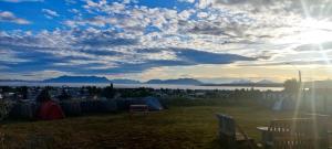 a view of a field with a view of the water at Camping Güino in Puerto Natales