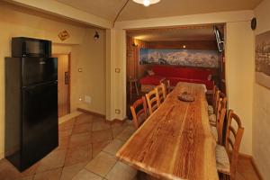 a kitchen with a wooden table and a refrigerator at Eydappartamenti in Sauze dʼOulx