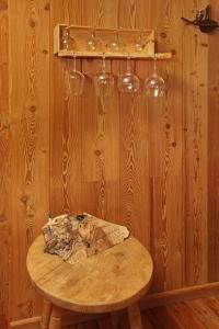 a wooden table with wine glasses on a wooden wall at Eydappartamenti in Sauze dʼOulx