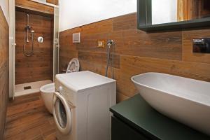 a bathroom with a sink and a washing machine at Eydappartamenti in Sauze dʼOulx