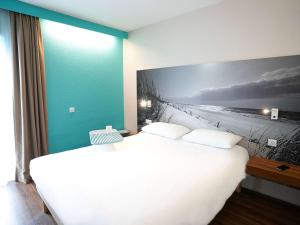 Una cama o camas en una habitación de ibis Styles Quimper