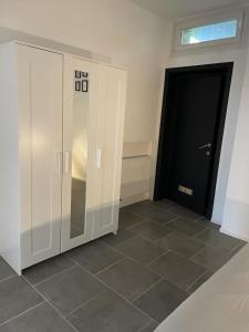 Cette chambre comprend une armoire blanche et une porte noire. dans l'établissement Station 171 Bruxelles-charleroi-airport, à Charleroi