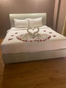 Una cama con una decoración de corazón. en Sinakhone Vientiane Hotel, en Vientiane