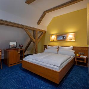 - une chambre avec un lit et un miroir dans l'établissement Altstadthotel der Patrizier, à Ratisbonne