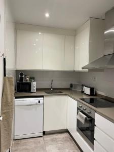 una cucina con armadi bianchi e lavandino di Nice Apartment 2 Bedrooms Well Connected a Cornellà de Llobregat