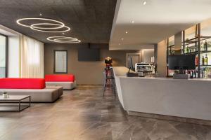 a lobby with a couch and a bar in a building at Amedia Milan, Trademark Collection by Wyndham in Milan