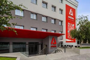 a hotel with a red sign on the side of a building at Amedia Milan, Trademark Collection by Wyndham in Milan