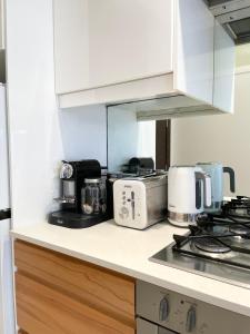 una cucina con piano di lavoro con elettrodomestici di Stylish apartment in the heart of Potts Point a Sydney