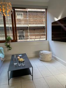 un soggiorno con tavolo e finestra di Stylish apartment in the heart of Potts Point a Sydney