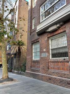 un edificio in mattoni con un albero di fronte di Stylish apartment in the heart of Potts Point a Sydney