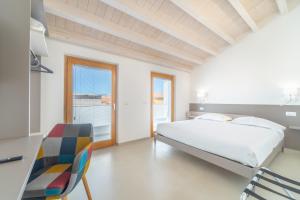 Schlafzimmer mit einem Bett, einem Schreibtisch und Stühlen in der Unterkunft Nuova -Luxury Rooms & Apartment- in Olbia