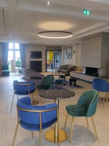 a lobby with tables and chairs and a living room at Logis Hôtel Les Tuileries in Féy