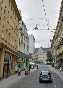 a car driving down a city street with buildings at Studio Apartement in Halle in Halle an der Saale