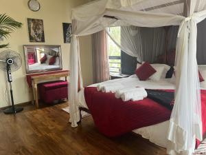 een slaapkamer met een hemelbed en een ventilator bij Florances Rest House in Nairobi