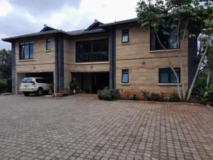 een huis met een auto ervoor geparkeerd bij Florances Rest House in Nairobi