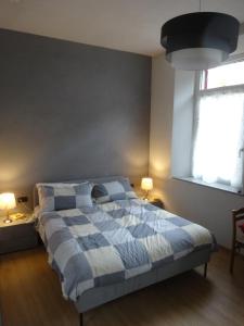 - une chambre avec un lit bleu et blanc et 2 lampes dans l'établissement Notte di Note - home hospitality, à Busto Arsizio