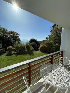 una mesa y una silla en un balcón con vistas en Luxury apartment, en Crans-Montana