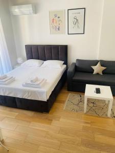 een slaapkamer met een bed en een bank bij Apartman PORTO in Trebinje