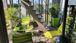 einen Balkon mit grünen Stühlen und eine Treppe mit Pflanzen in der Unterkunft Location chambre privée avec salle de bain et WC privatifs dans appartement moderne in Nantes