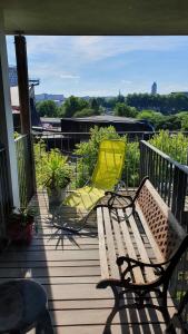 eine Terrasse mit einer Bank und einem gelben Stuhl in der Unterkunft Location chambre privée avec salle de bain et WC privatifs dans appartement moderne in Nantes