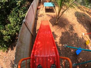 un banco rojo sentado junto a una pared en Wow Farm House, en Auroville